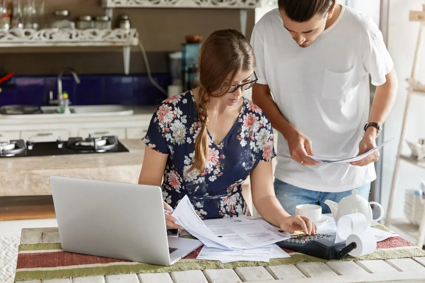 A couple managing a budget together in the kitchen.